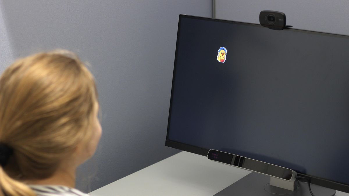 Photo of a girl looking at a screen with an eye tracking device attached. 