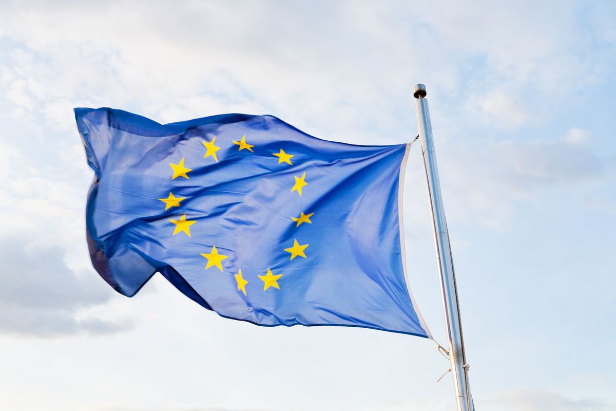 Diese Fotografie zeigt eine Europaflagge, die im Wind weht.