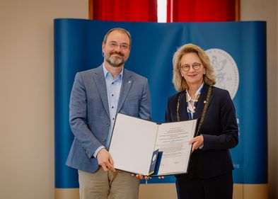 Das Bild zeigt Prof. Dr. Christian Wirth, wie er gerade die Urkunde zur Aufnahme in die Leopoldina von Leopoldina-Präsidentin Prof. Dr. Bettina Rockenbach bekommt.