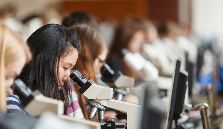 Foto: Studentinnen sitzen im Mikroskopiersaal und schauen durch die Mikroskope