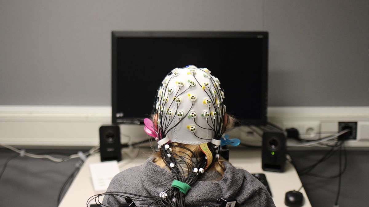 Kind mit EEG-Haube vor einem Bildschirm