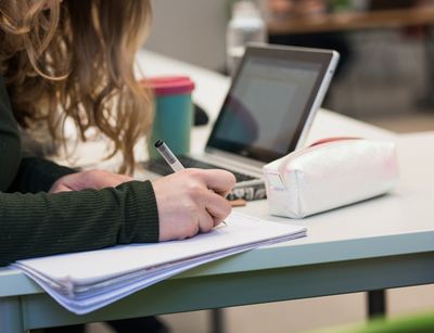 A student takes notes during the lecture