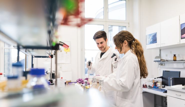 Colour photo: A man and a woman stand in the laboratory and work with scientific instruments.